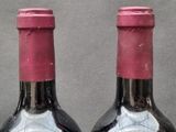 two bottles of wine sitting next to each other on a table