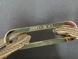 a close up of a gold tie bar with a snake on it