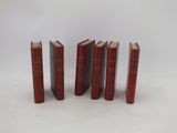 five red books are lined up in a row on a white surface