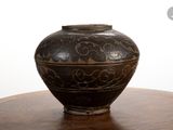 a black vase sitting on top of a wooden table