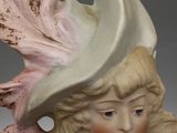 a figurine of a little girl with a hat on her head