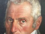 portrait of a man with a white beard and a green jacket