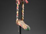 une sculpture en bois représentant la tête et le pied d'une femme, posée sur un socle