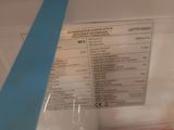 a piece of blue tape on the top of a refrigerator door