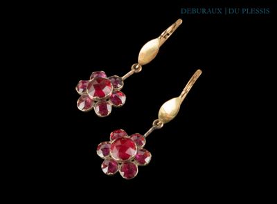 une paire de boucles d'oreilles ornées de pierres rouges sur fond noir