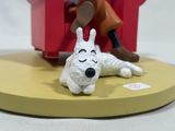 a figurine of a dog that is laying on a table