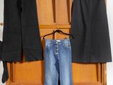 three pairs of jeans hanging on a clothes rack