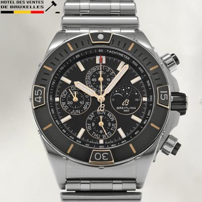 a close up of a stainless steel watch with a black face