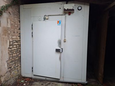 une porte blanche ouverte dans un bâtiment en pierre