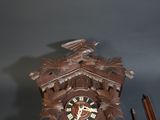a wooden clock with a bird on the top of it