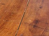a close up of a wooden table with peeling paint on it