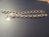 a silver chain with a tag on it on a table