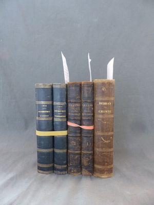 trois vieux livres sont empilés sur une table