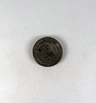 un gros plan d'une pièce de monnaie percée d'un trou au milieu
