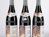 trois bouteilles de vin décorées de paillettes, posées les unes à côté des autres