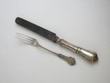 deux fourchettes et un couteau sur une table blanche