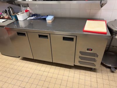 a kitchen with stainless steel counter tops and a metal cabinet