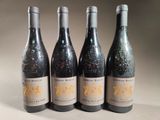 four bottles of wine are lined up on a table