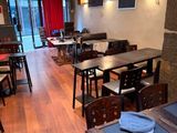 des tables et des chaises dans un restaurant avec des rideaux rouges accrochés au mur