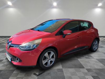 une voiture rouge est garée dans une pièce au sol en damier