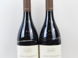 deux bouteilles de vin posées l'une à côté de l'autre sur une surface blanche