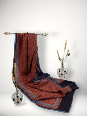a red and blue towel on a towel rack next to a vase of flowers