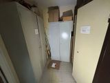 a white refrigerator in a room with a lot of boxes on the floor