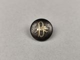 un bouton noir et doré orné d'un cheval