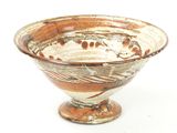a brown and white bowl sitting on a white surface