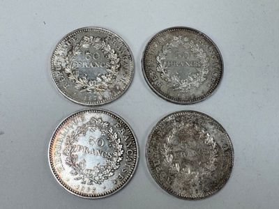 quatre pièces d'argent empilées les unes sur les autres sur une surface blanche