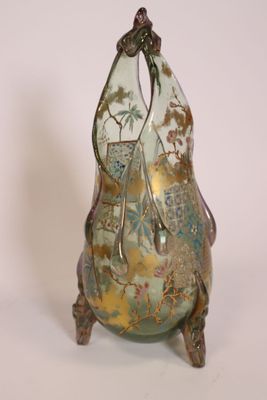 a glass vase with a gold and green design on it