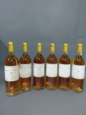 six bouteilles de vin sont alignées sur une table