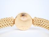an image of a close up of a gold bracelet on a white surface