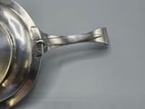 a silver plate with a spoon on it on a table