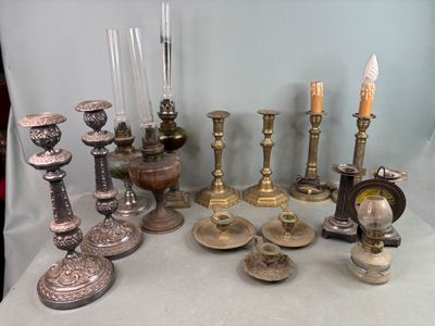 de nombreux types de bougies et de bougeoirs sur la table