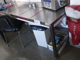 une petite table sur laquelle est posé un micro-ondes