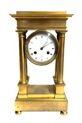 a gold clock that is sitting on top of a table