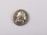 Gros plan sur une pièce de monnaie en argent portant un visage de femme