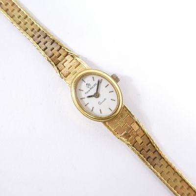 a close up of a gold wrist watch on a white surface