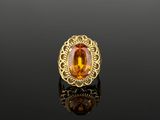 a yellow gold ring with an oval citrine stone surrounded by filigree filigree