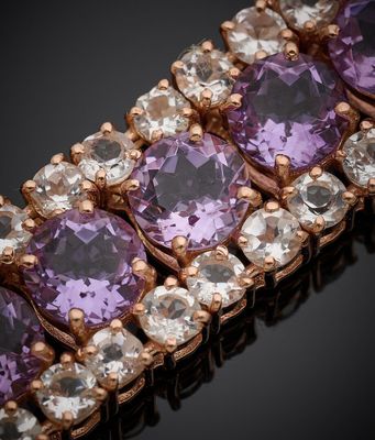 un gros plan sur un bracelet orné de pierres violettes et blanches
