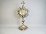 a silver and gold clock with a cross on top of it