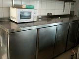 un micro-ondes posé sur un plan de travail dans une cuisine équipée d'armoires en acier inoxydable