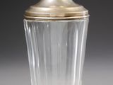 a glass jar with a gold lid sitting on a table