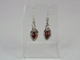 a pair of silver earrings with red stones on them