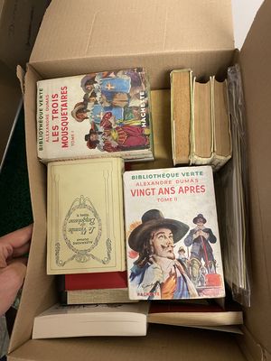 une boîte pleine de livres posée sur une table
