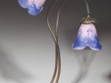 a lamp that is sitting on a table with two flowers on it