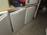 several refrigerators and freezers are stacked on a counter in a kitchen
