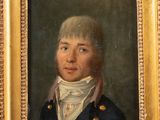 portrait of a man in a blue coat and white shirt in a gold frame