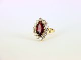une bague en or sertie d'une pierre rouge entourée de diamants blancs